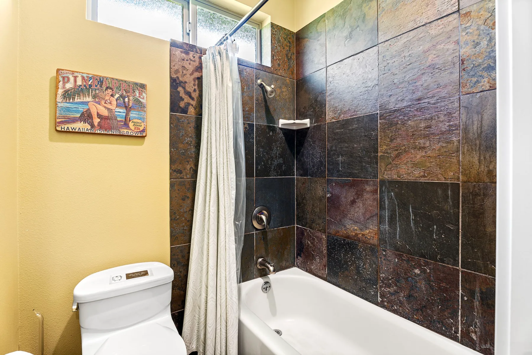 A bathroom with a bathtub, shower curtain, and tiled walls.