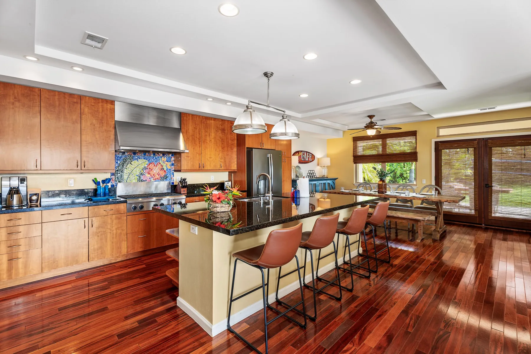 A bright kitchen with a central island, bar seating, and wooden cabinetry.