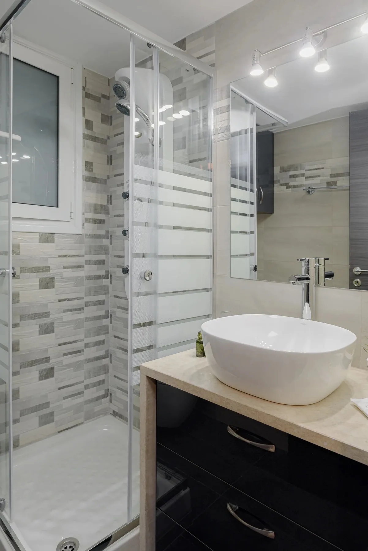A modern bathroom with a glass shower and a vessel sink on the vanity.