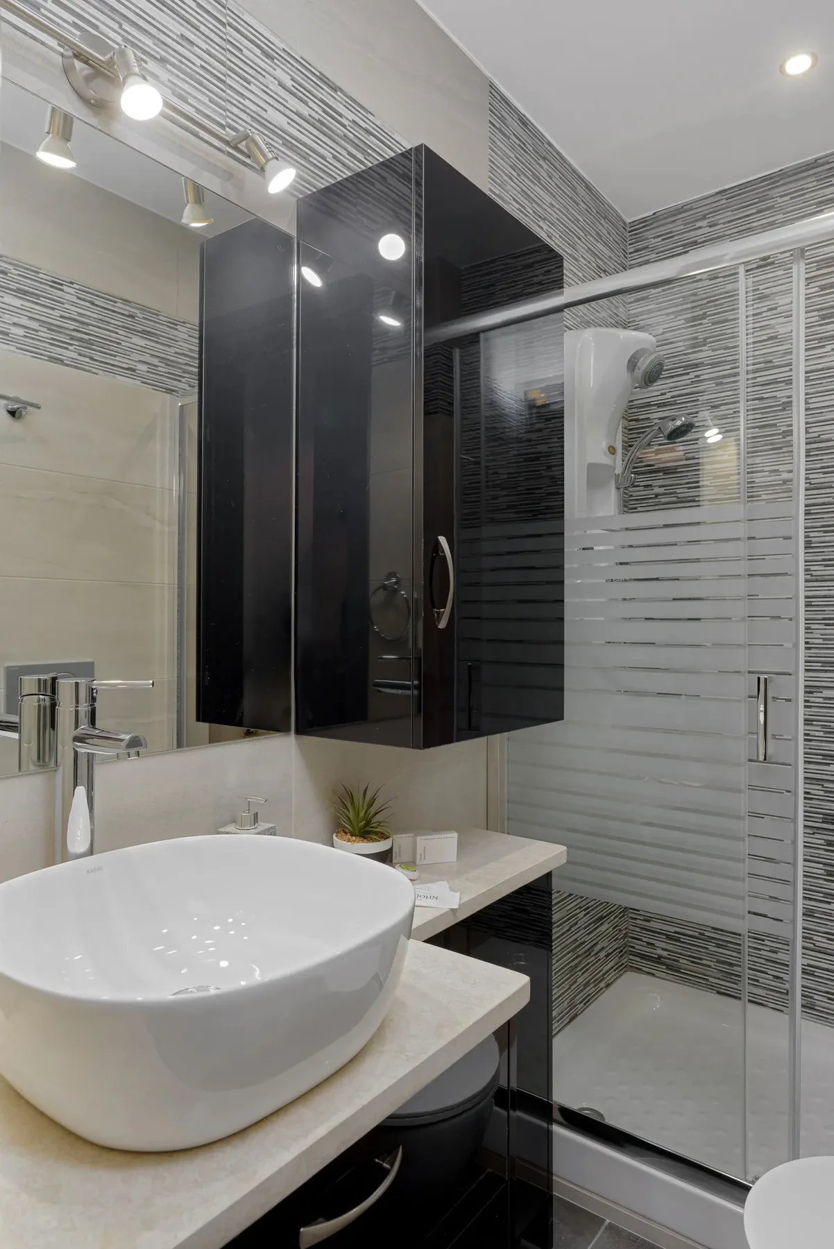 A modern bathroom with a vessel sink and glass shower.