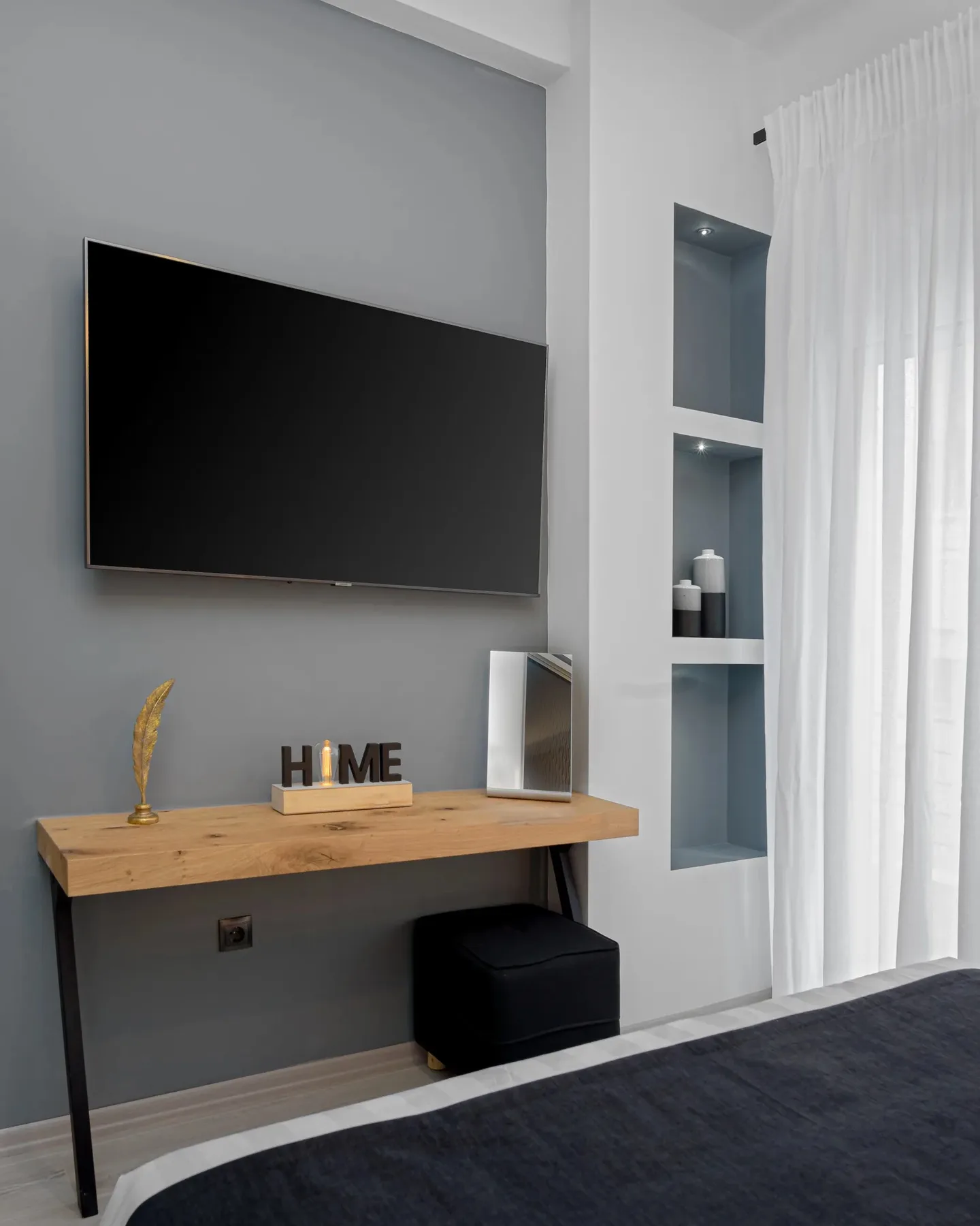 A living area with a wall-mounted television above a wooden console.