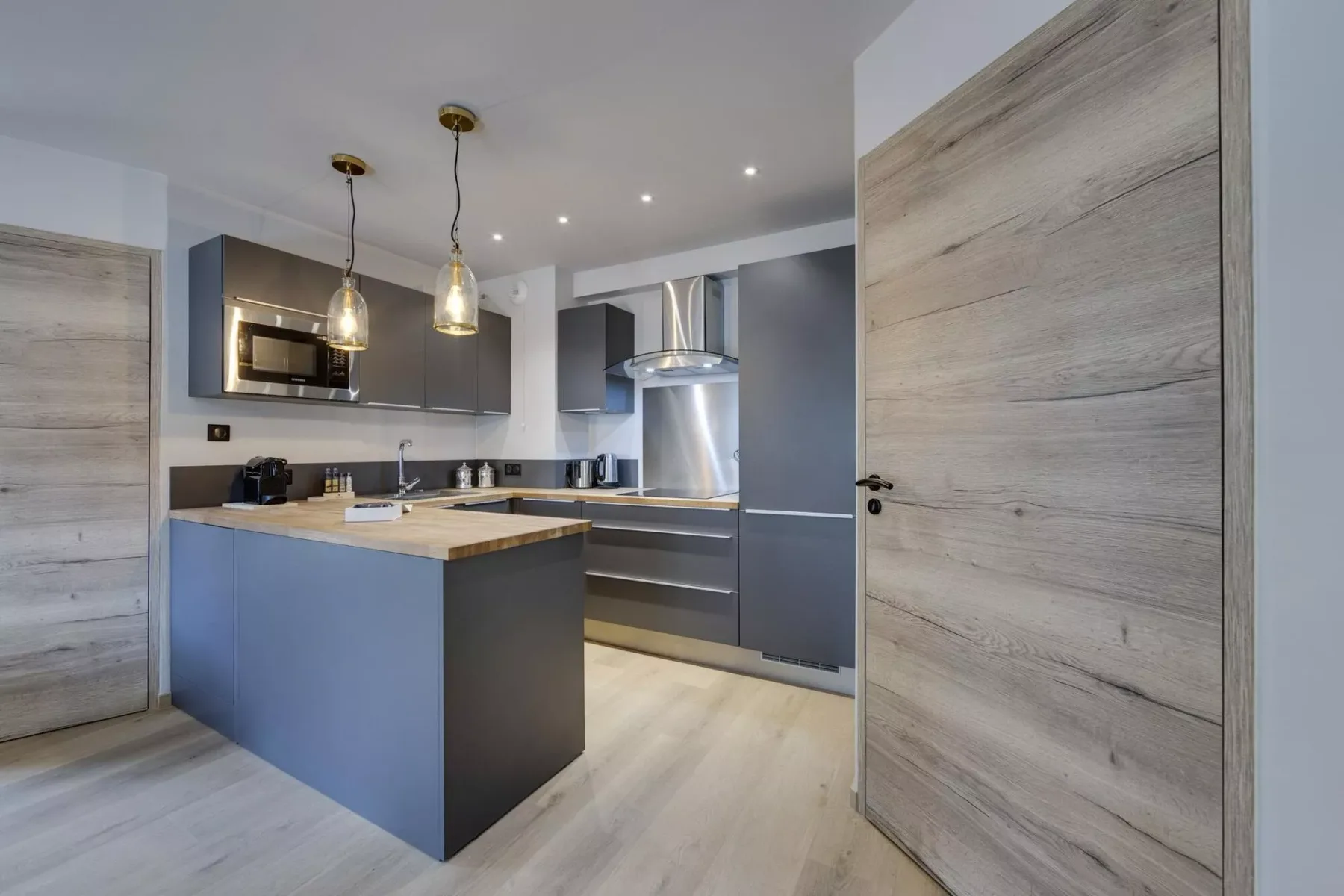 Una cocina moderna con gabinetes oscuros y una isla central.
