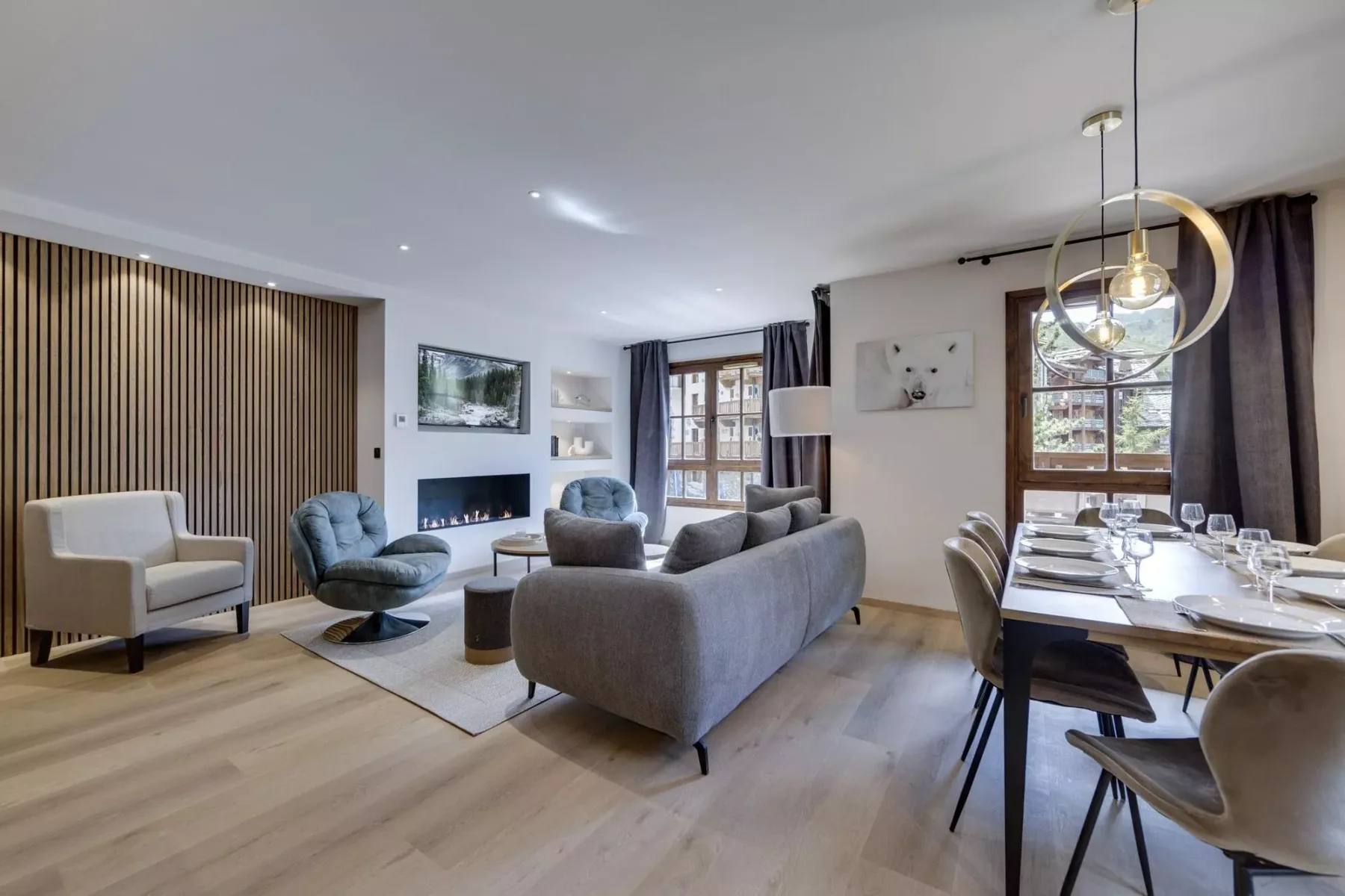 A living and dining area with seating, a fireplace, and a set dining table.