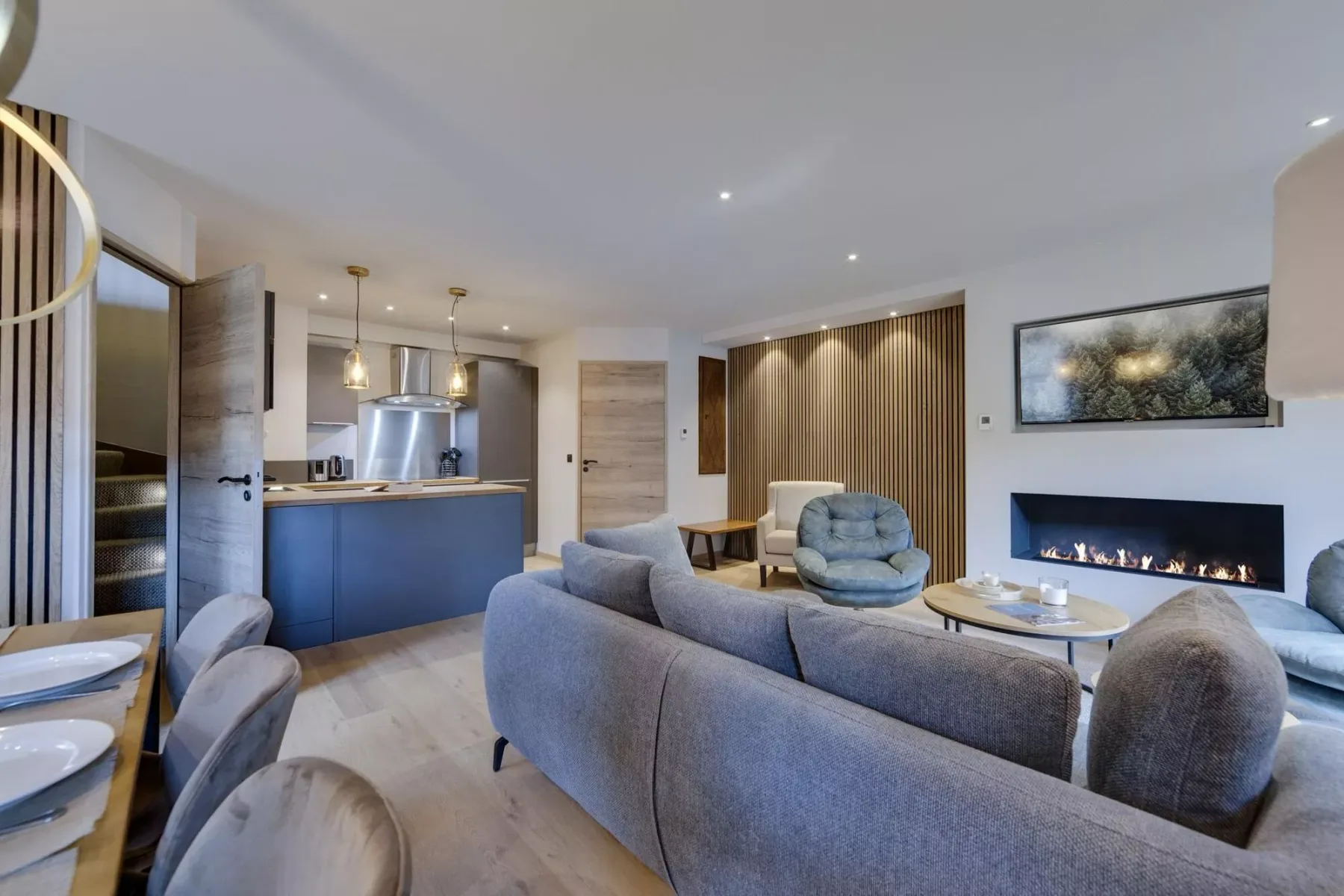 An open-plan living room and kitchen with seating around a low table.