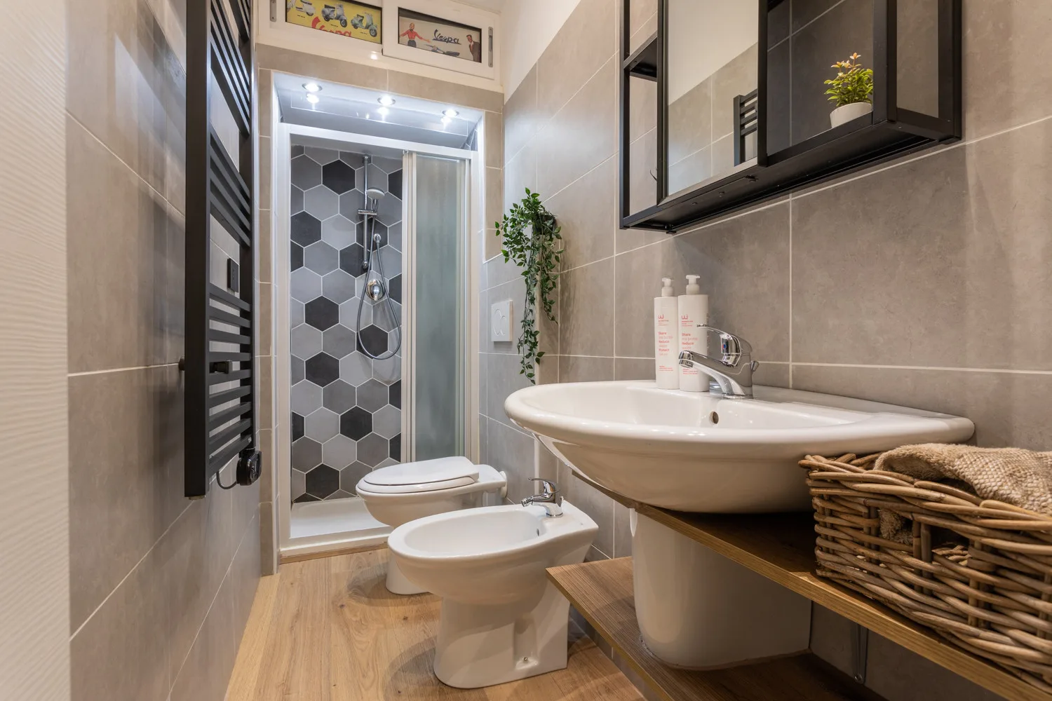 A tiled bathroom with a shower, toilet, bidet, and sink.