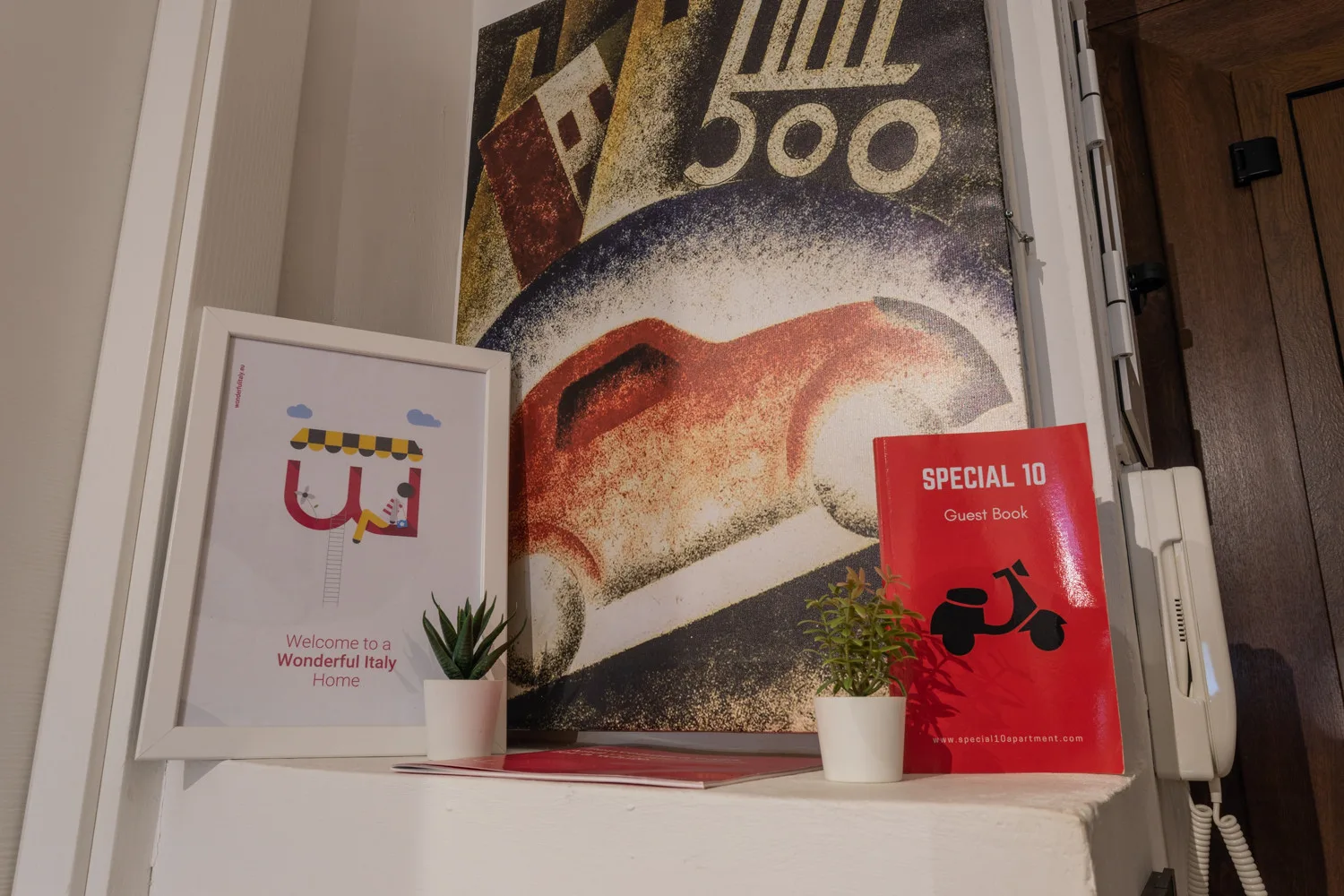 An entryway wall displays colorful artwork, a welcome sign, and a guest book.