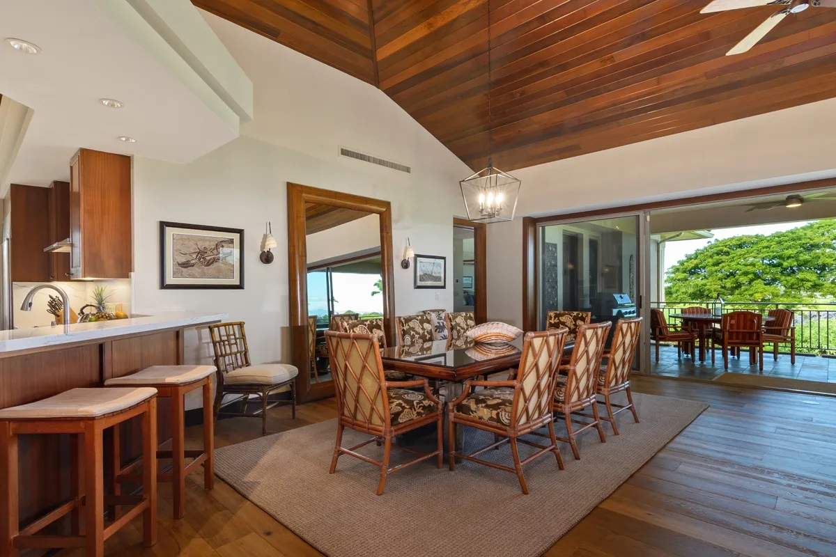 An open dining and kitchen area with a table beside sliding glass doors.