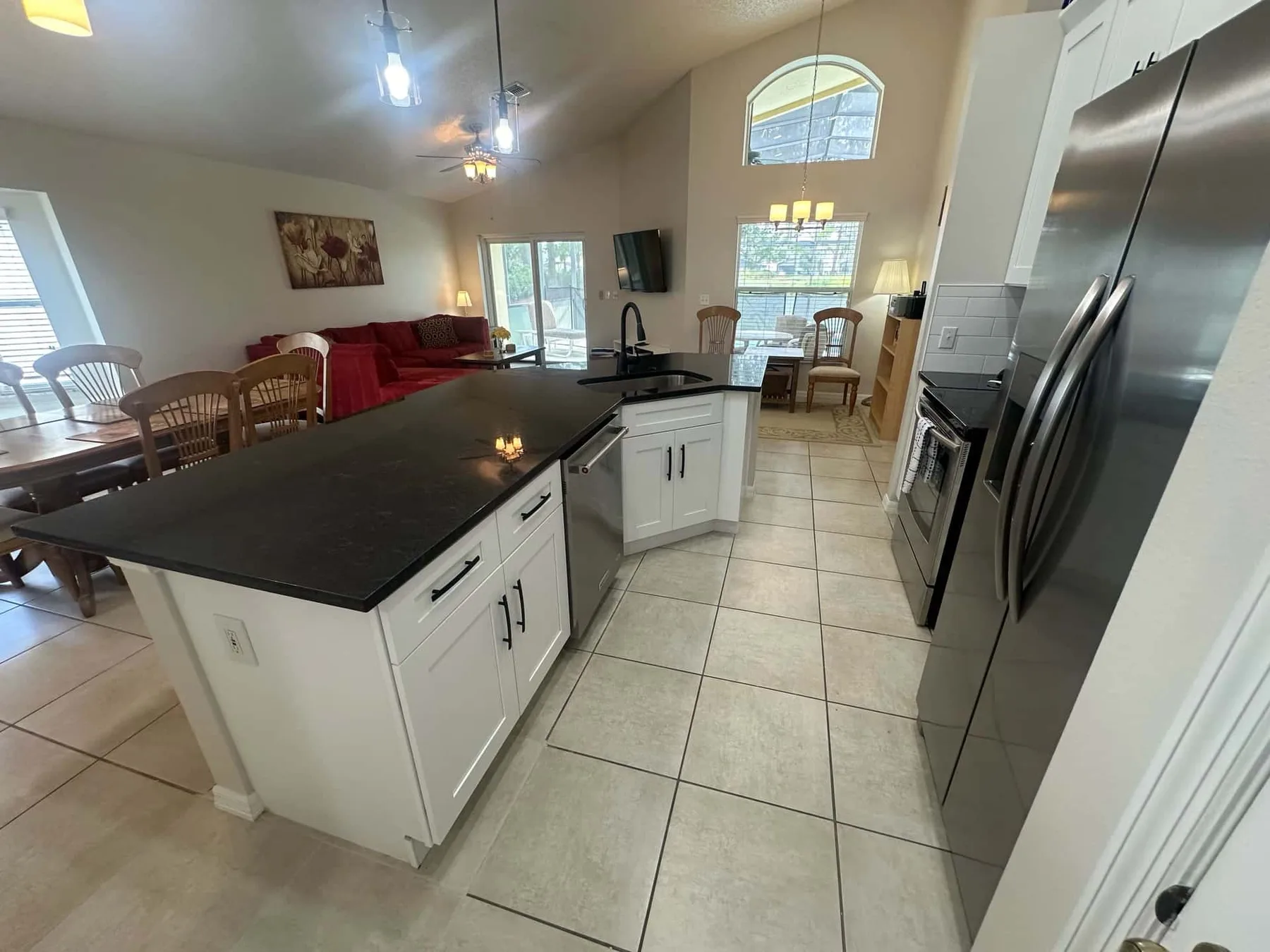 Cocina y sala de estar de planta abierta con una isla grande y una mesa de comedor.