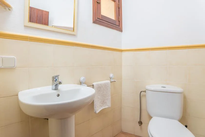 Un baño con lavabo, toalla e inodoro.