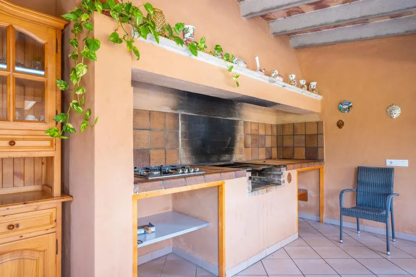 Una cocina con salpicadero de azulejos, estantes abiertos y un armario de madera.
