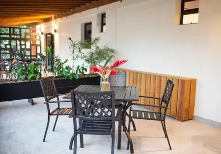 Outdoor table and chairs with a vase of flowers.