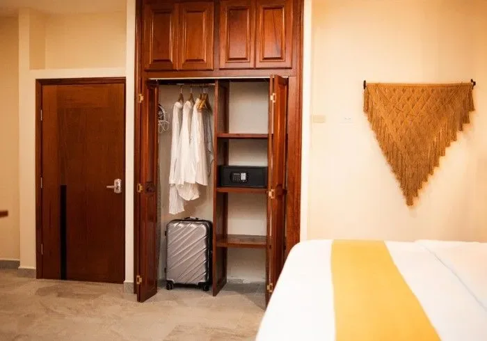 Hotel bedroom with a suitcase in the closet.