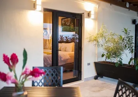 Patio with table and chairs beside a bedroom.