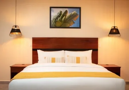 Habitación de hotel con una cama y un cuadro en la pared.