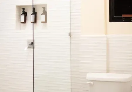 Bathroom with toilet and glass-enclosed shower.
