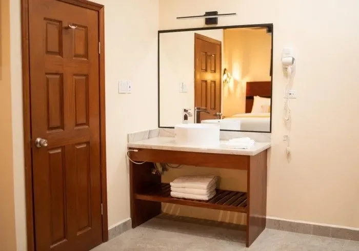 Hotel bathroom with sink and mirror.