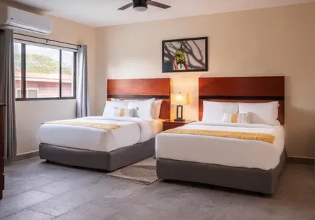 Hotel room with two beds and a ceiling fan.