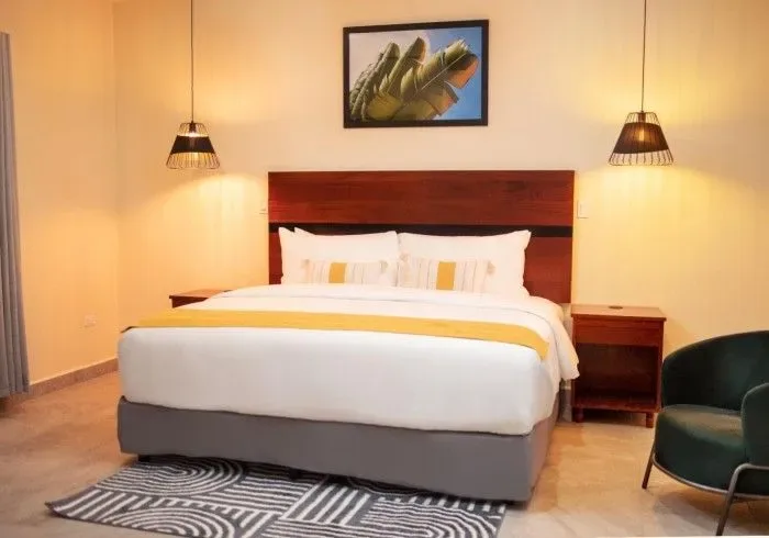 Hotel room with a king bed and chair.