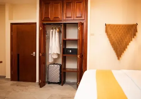Hotel bedroom with a suitcase in the closet.