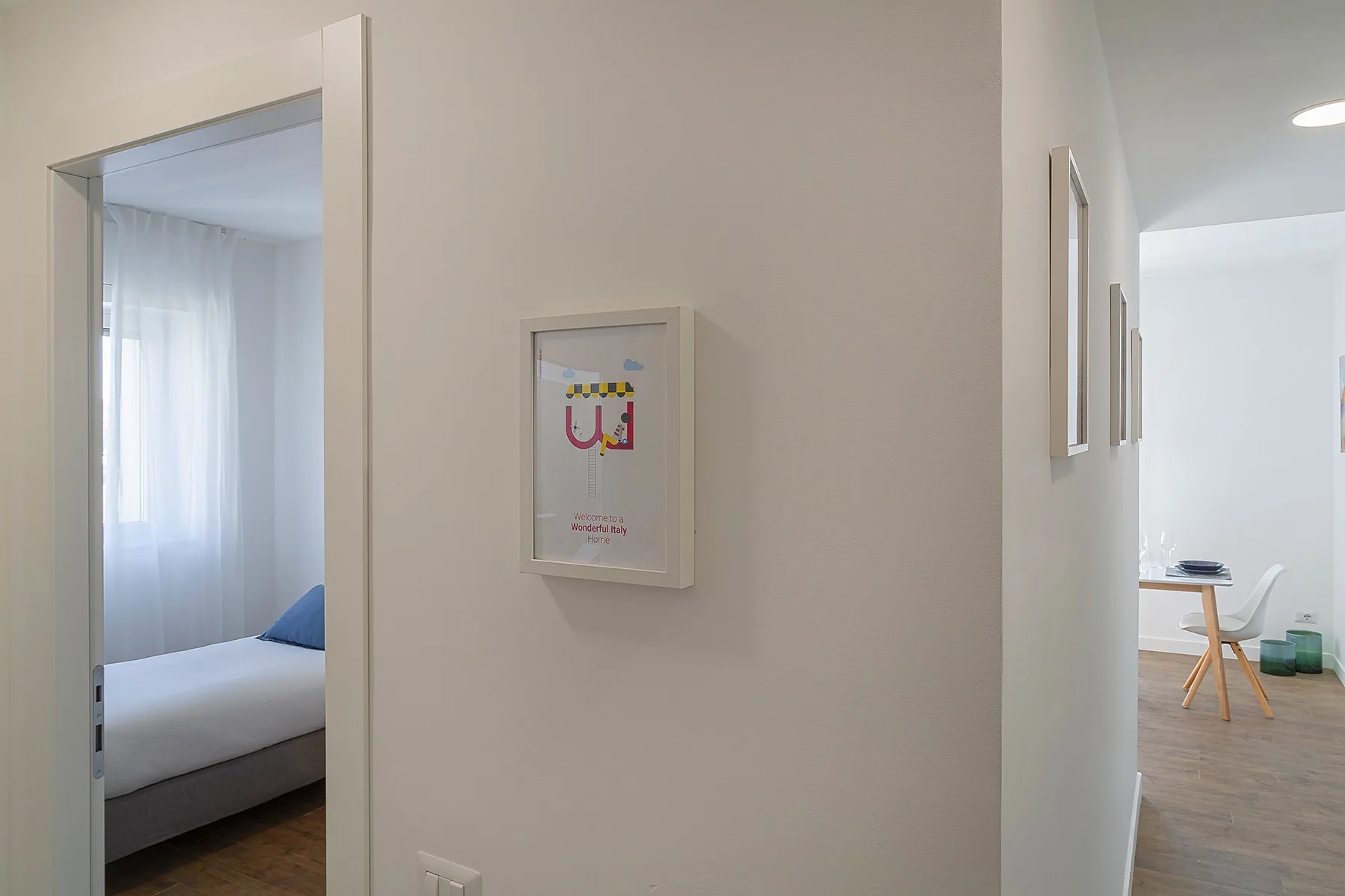 A bright interior hallway connects a bedroom and a dining area.