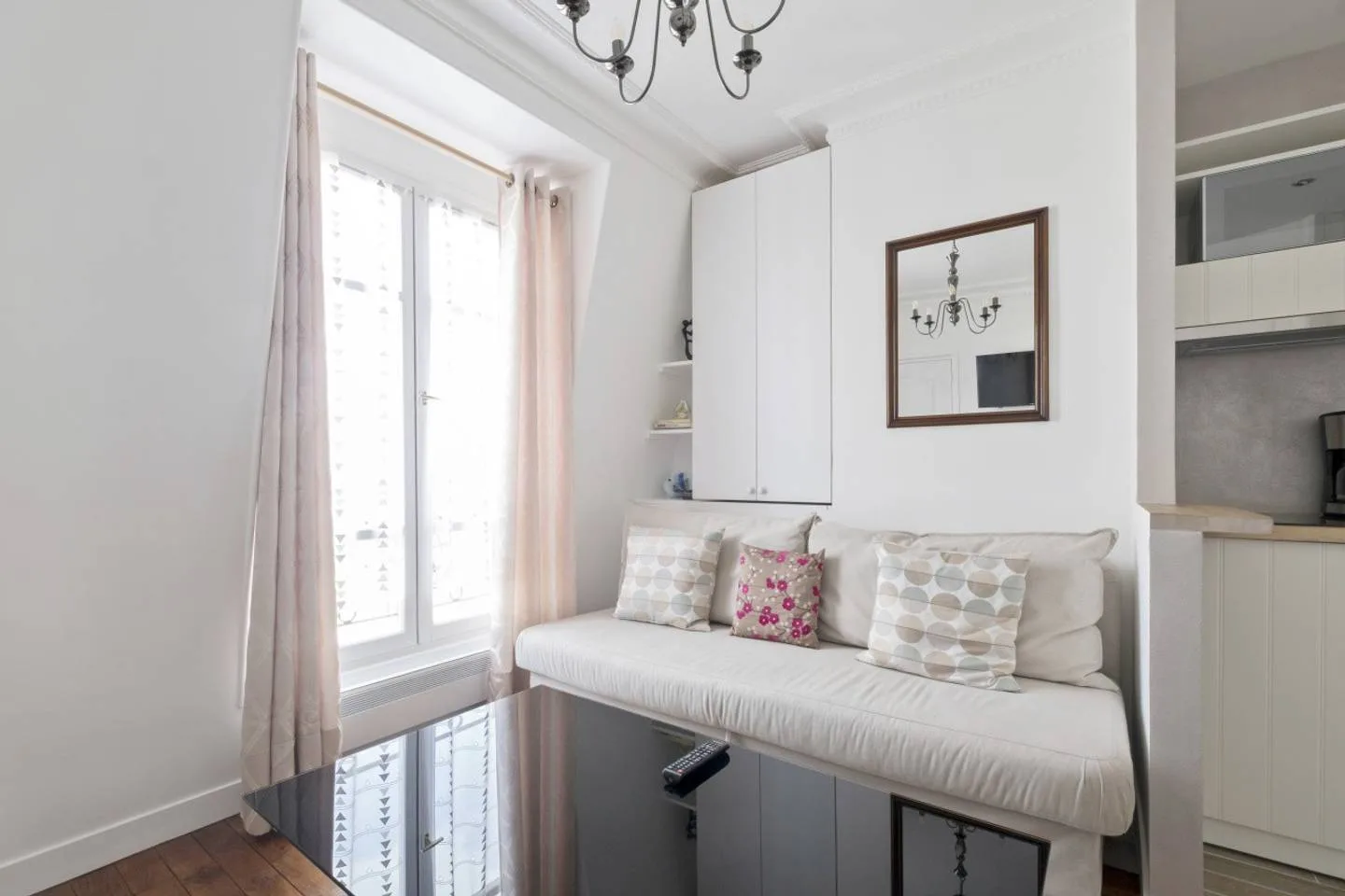 A bright sitting area has a cushioned bench beside a tall window.