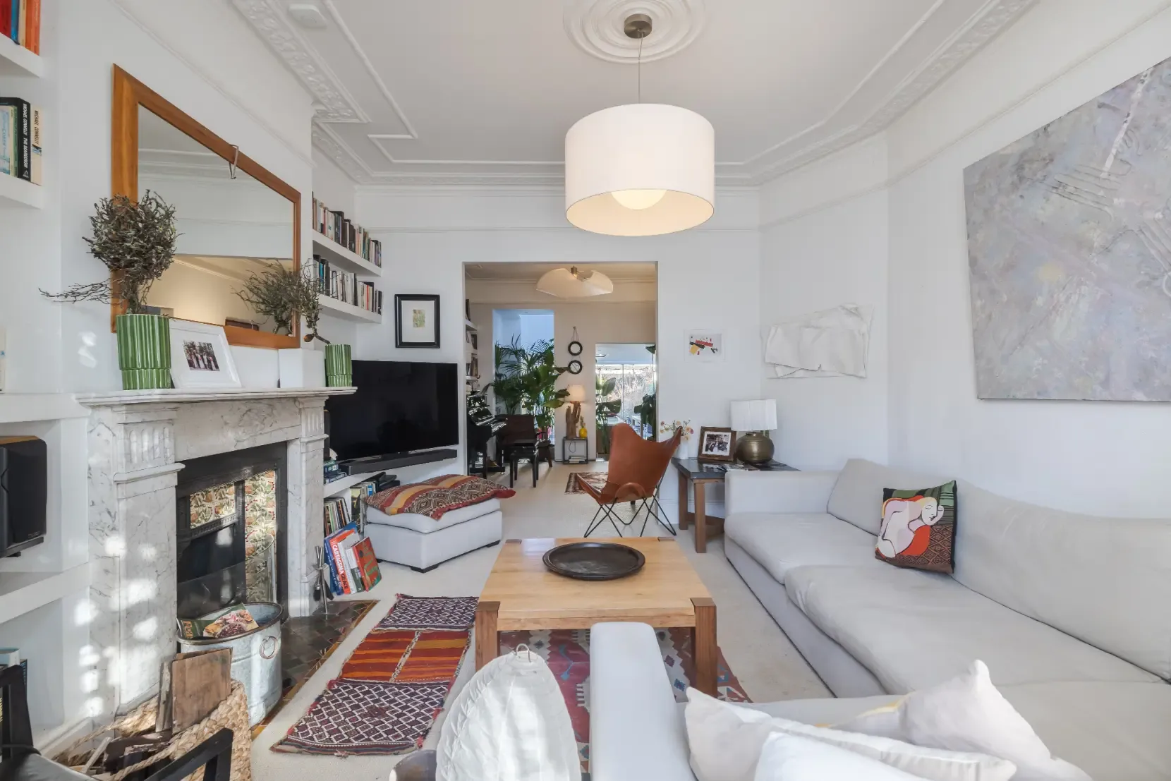 Una sala de estar luminosa con chimenea, asientos y una mesa de centro de madera.