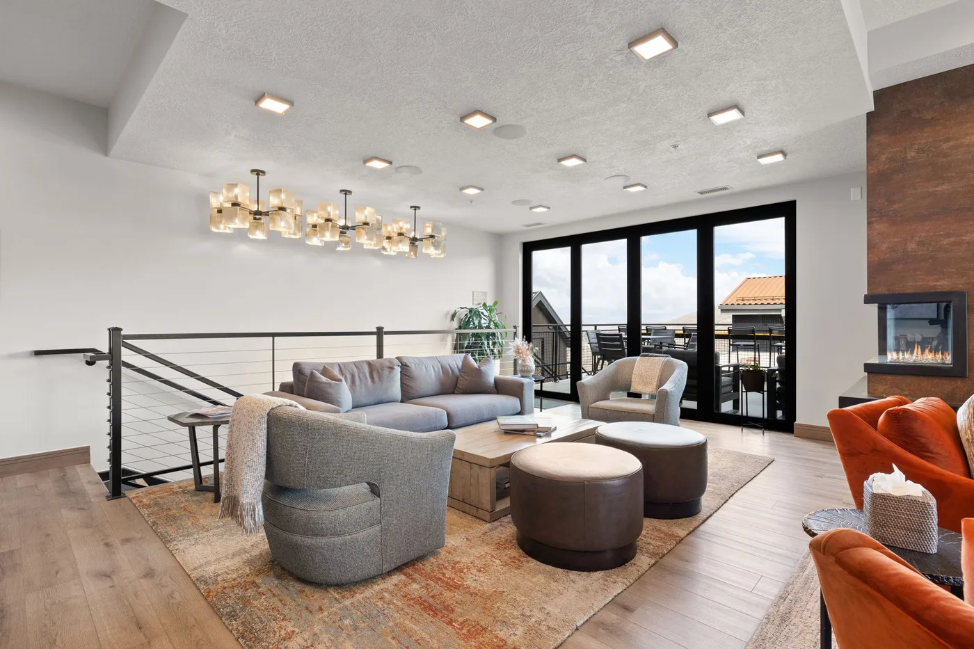Una sala luminosa con asientos alrededor de una mesa baja y grandes ventanas.