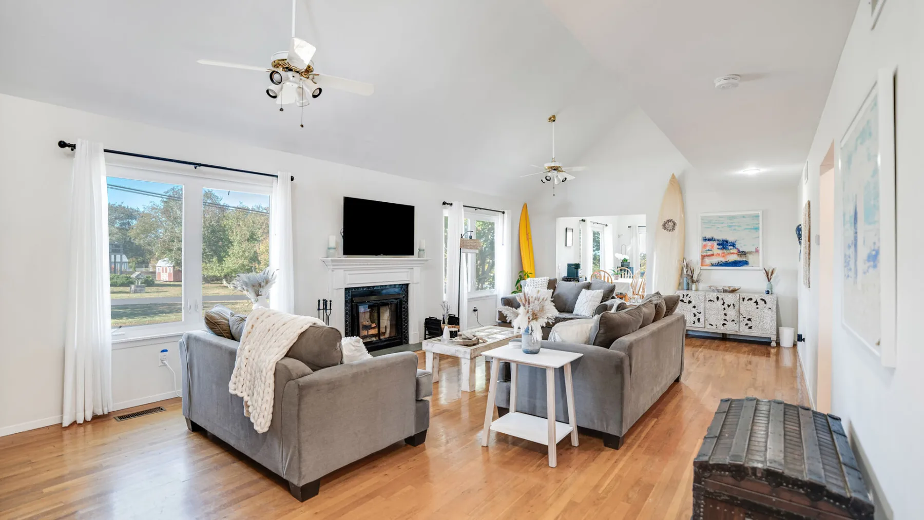 A bright living room with seating arranged around a coffee table and fireplace.