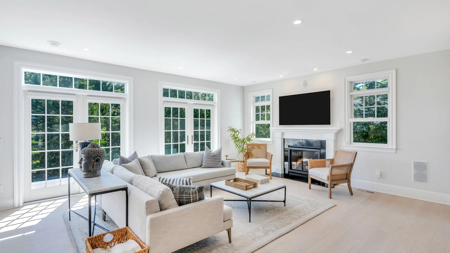 A bright living room with seating, a coffee table, and a fireplace.