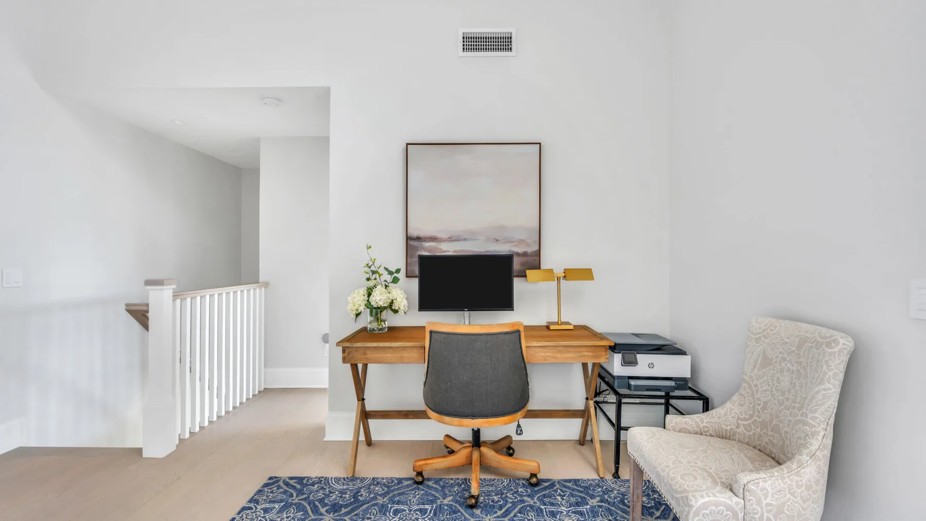A bright living area with a wooden desk, television, and upholstered seating.