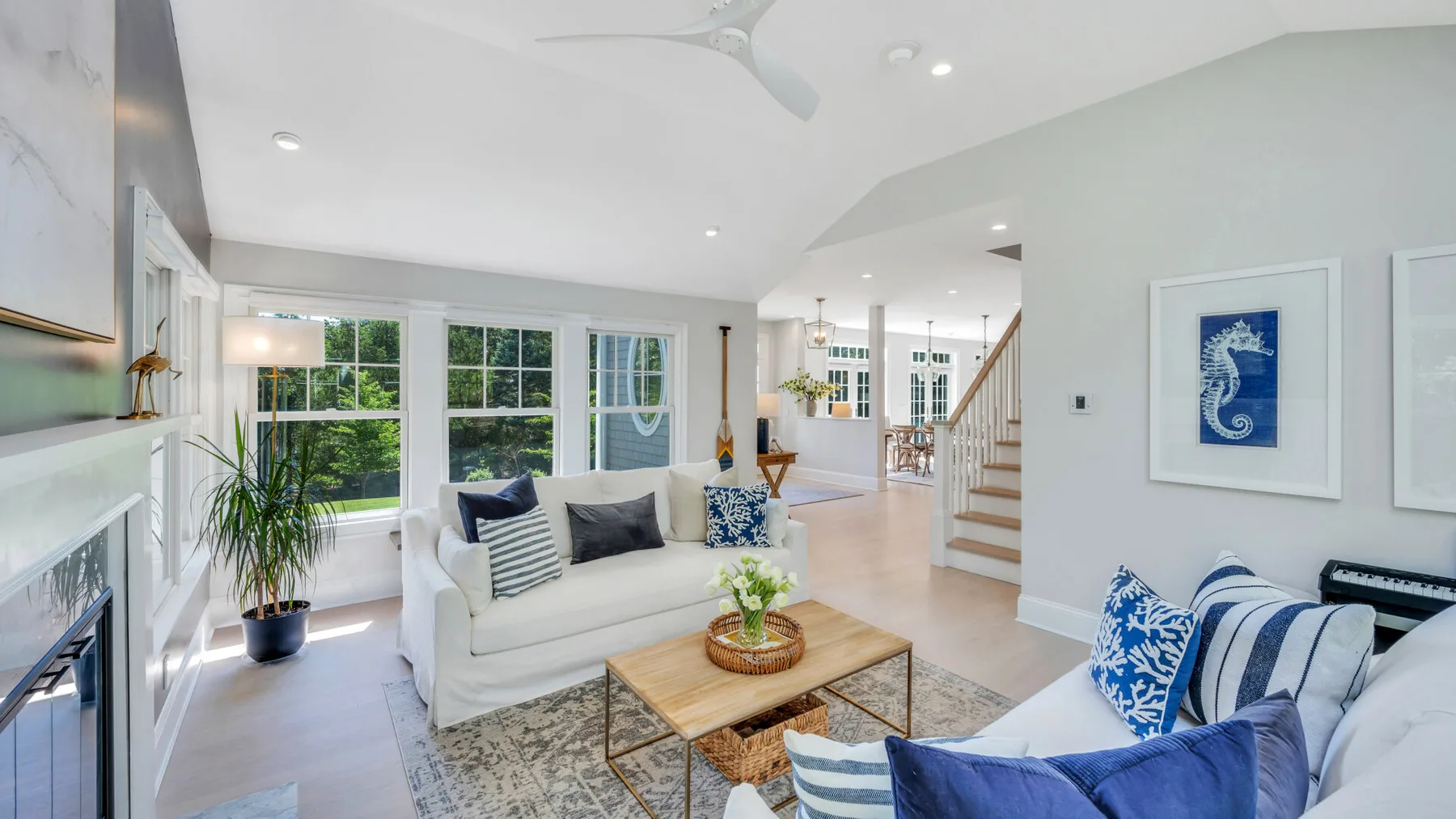 A bright living room with seating, large windows, and a coffee table.