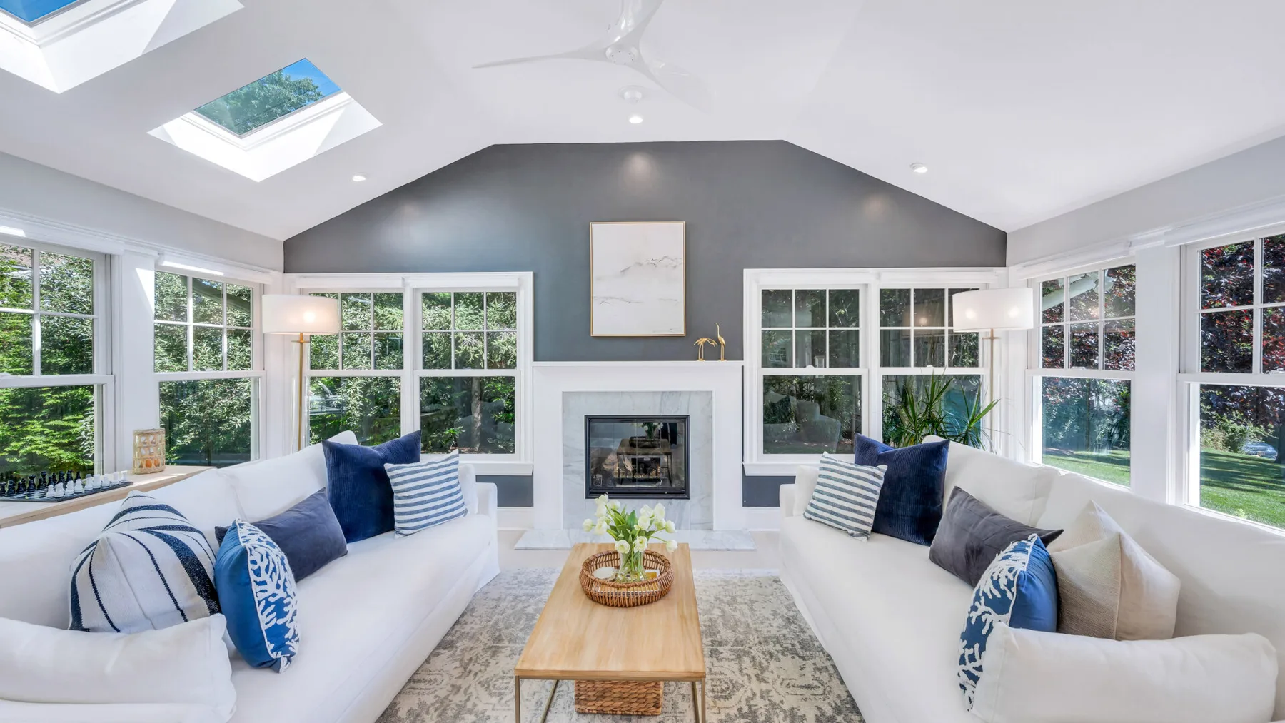 A bright living room with seating arranged around a fireplace and coffee table.