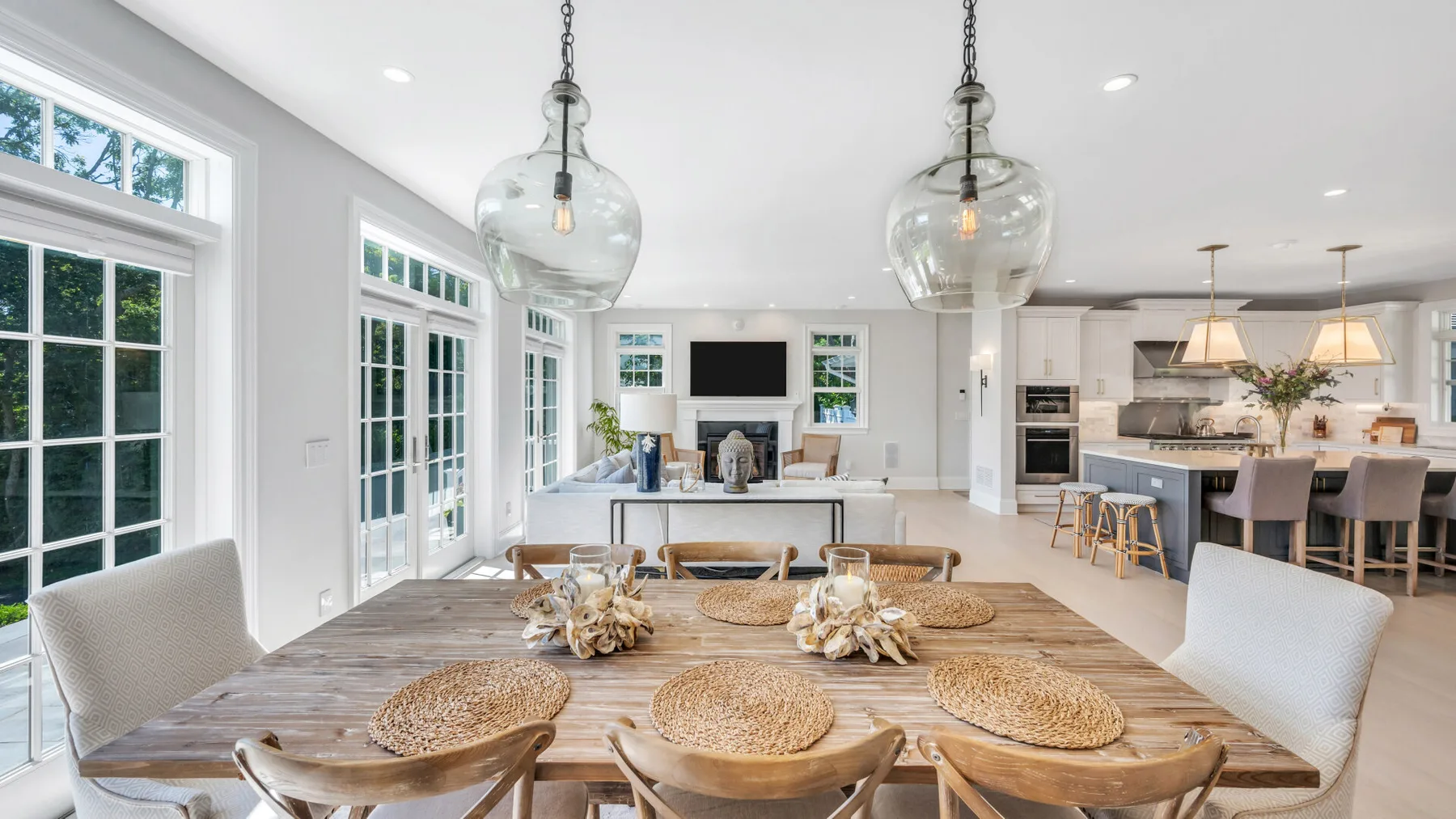 A bright open-plan kitchen and dining area with a long wooden table.