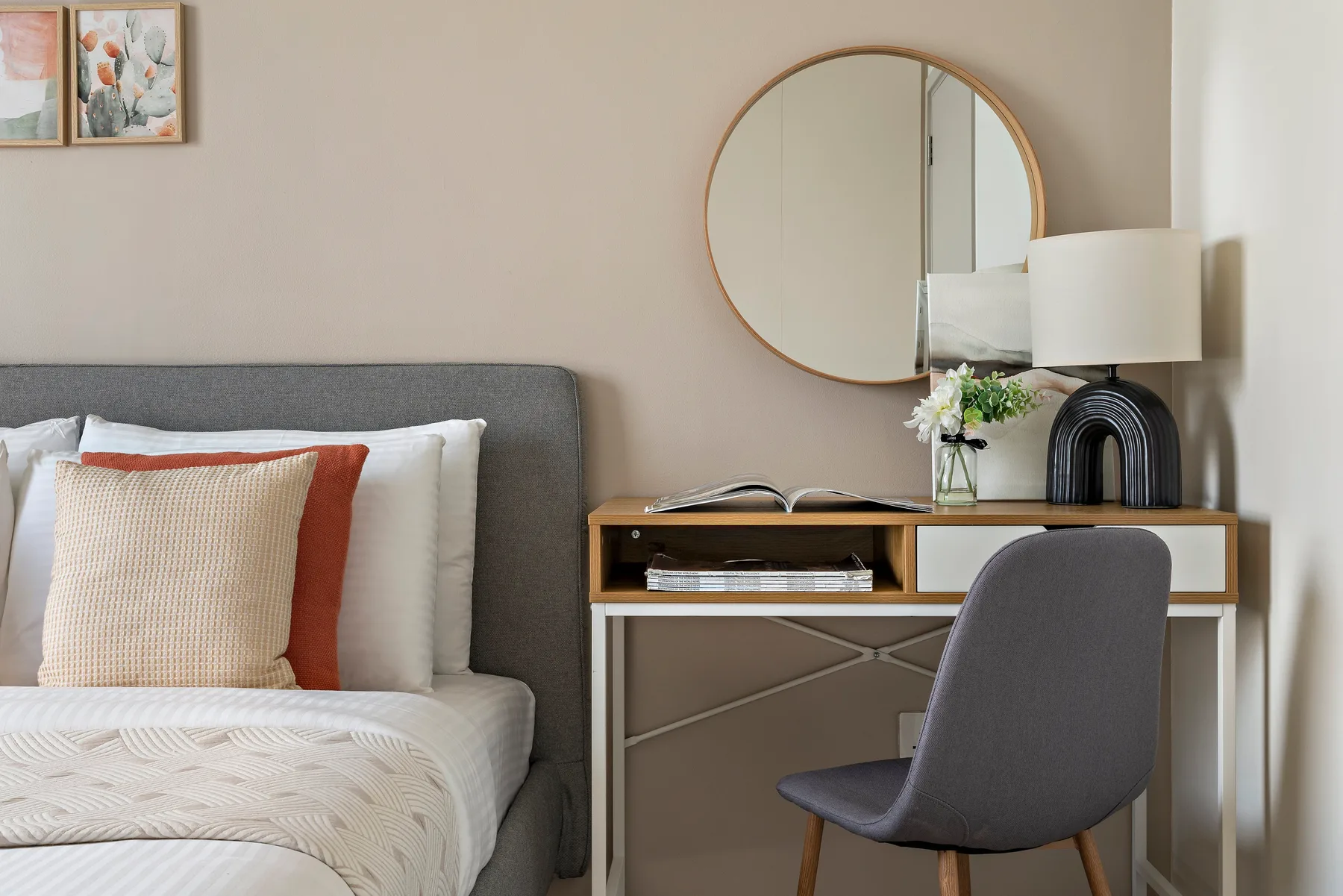 Un dormitorio con una cama tendida y un escritorio junto a la pared.