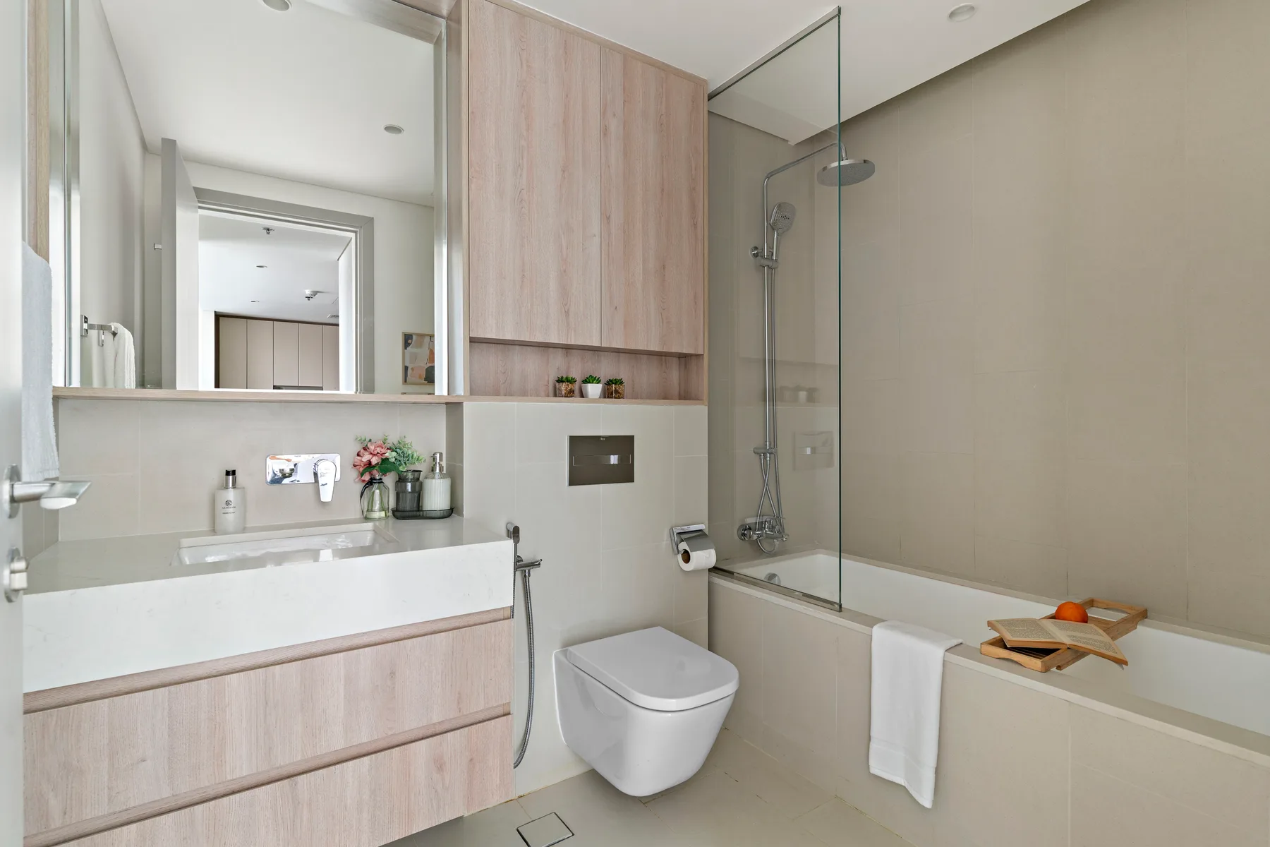 Un baño con lavabo, inodoro y bañera junto a una mampara de ducha de vidrio.