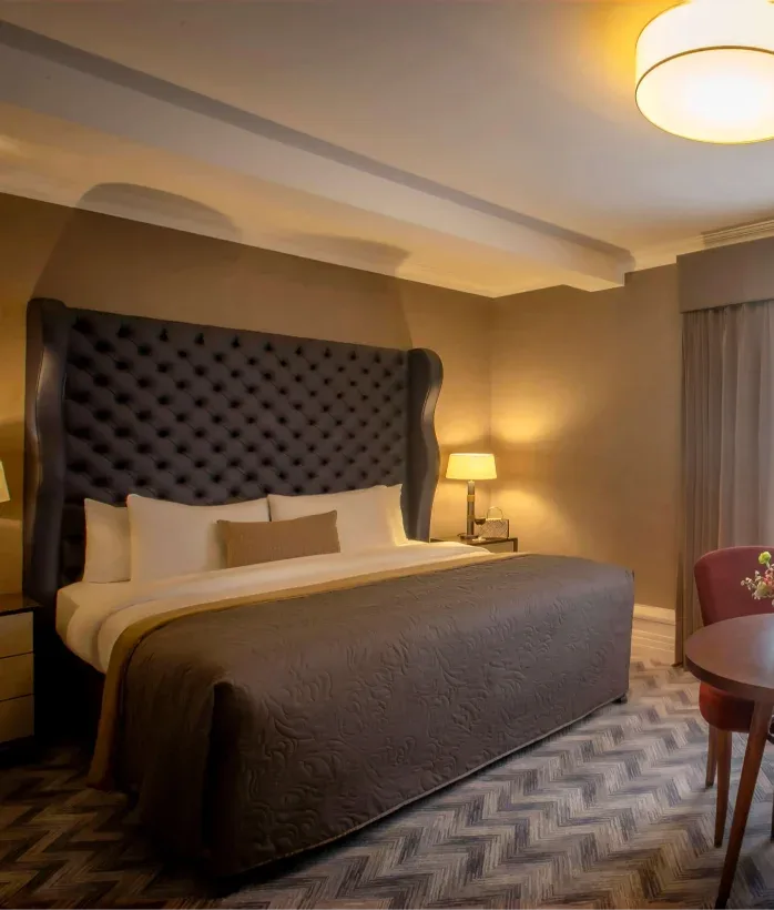 Hotel room seating area with flowers and wine.