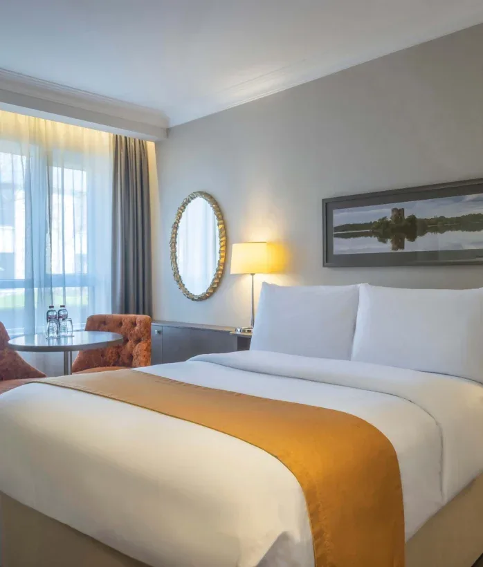 Hotel bedroom with double bed and seating.