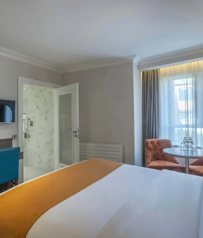 Hotel bedroom with seating area.