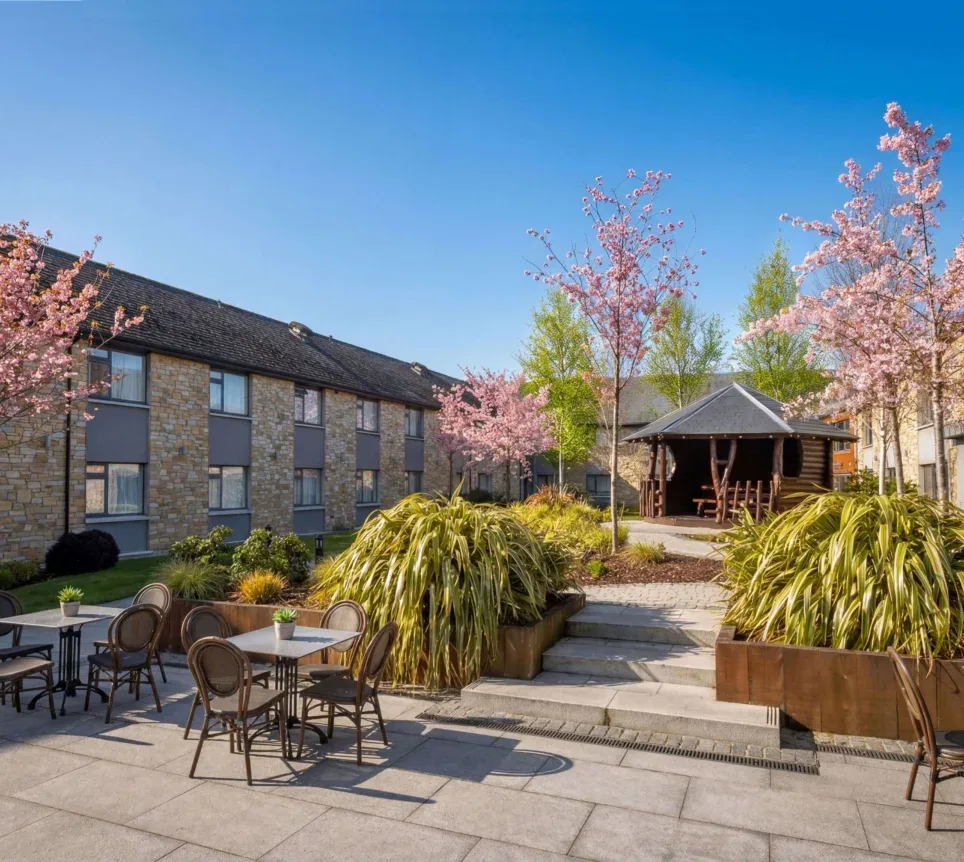 Hotel courtyard with tables, chairs and trees.