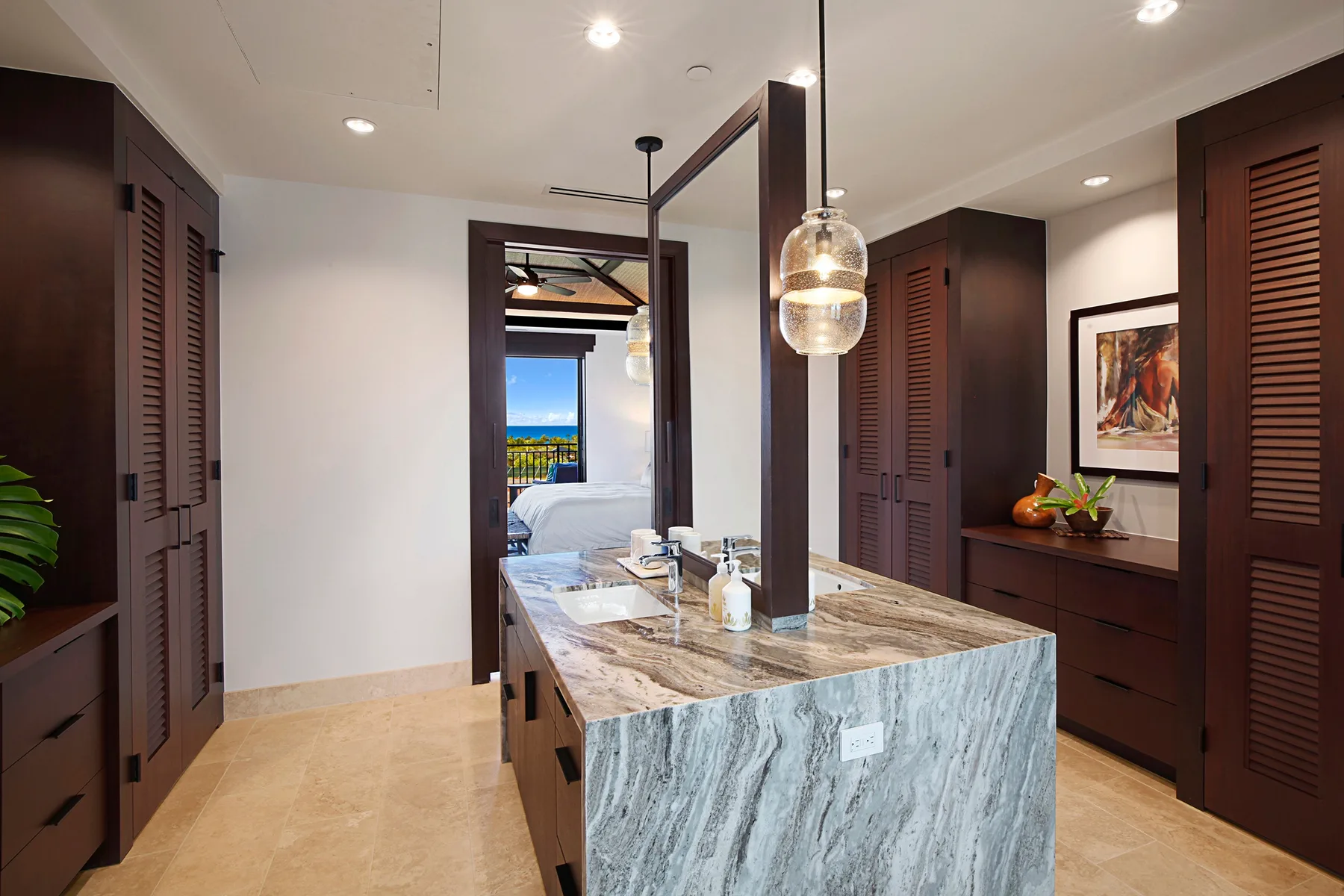 A modern kitchen with a large stone island and dark cabinets.