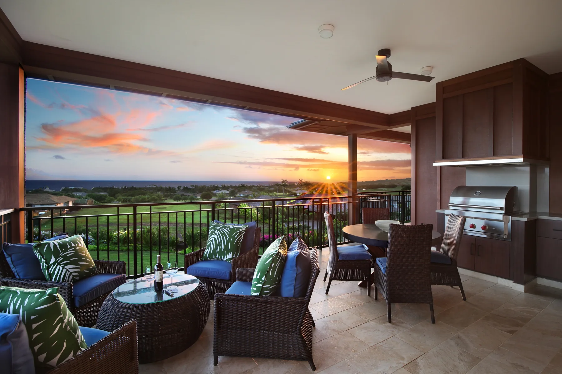 Una zona de estar exterior cubierta ofrece vistas a un paisaje verde al atardecer.
