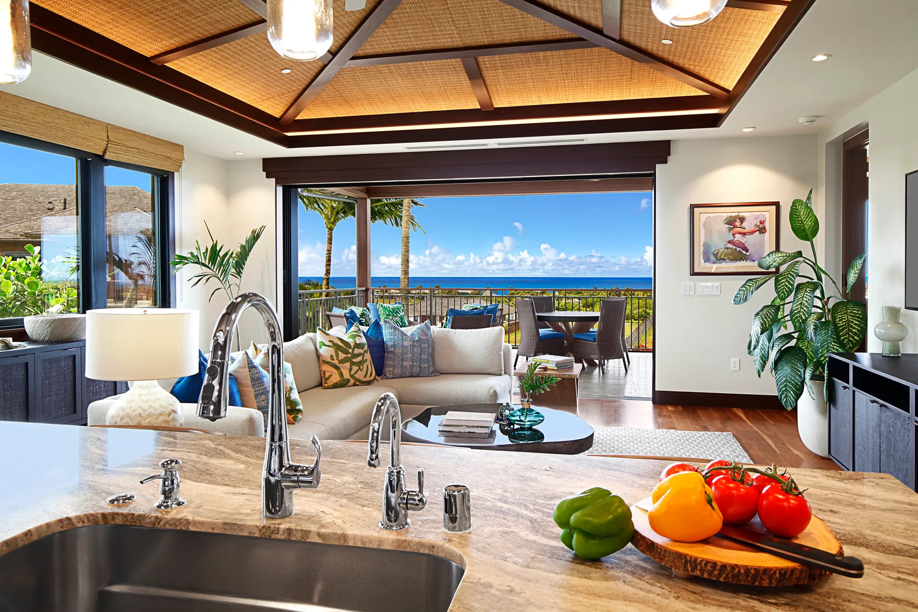 A kitchen opens onto a dining area and a balcony overlooking the ocean.