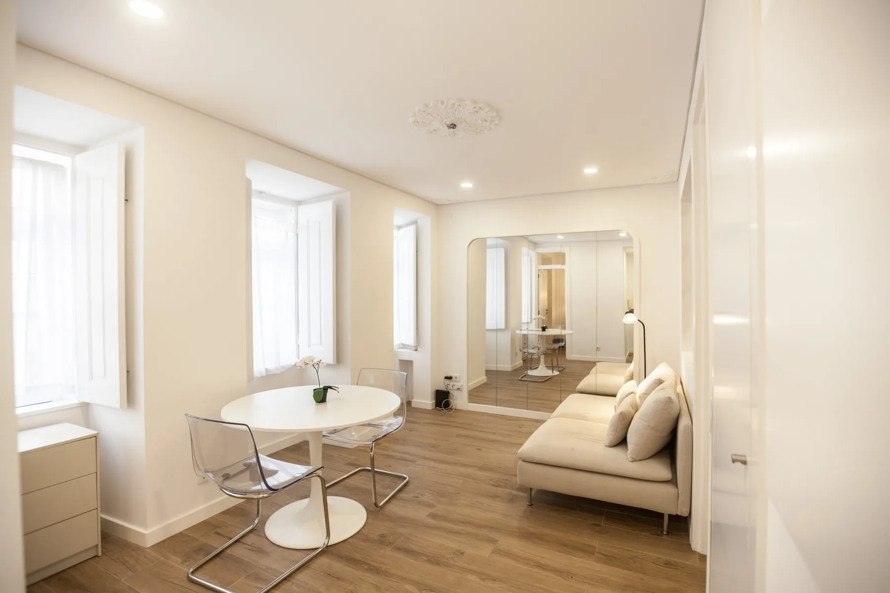 A bright living and dining area with a small table and seating.