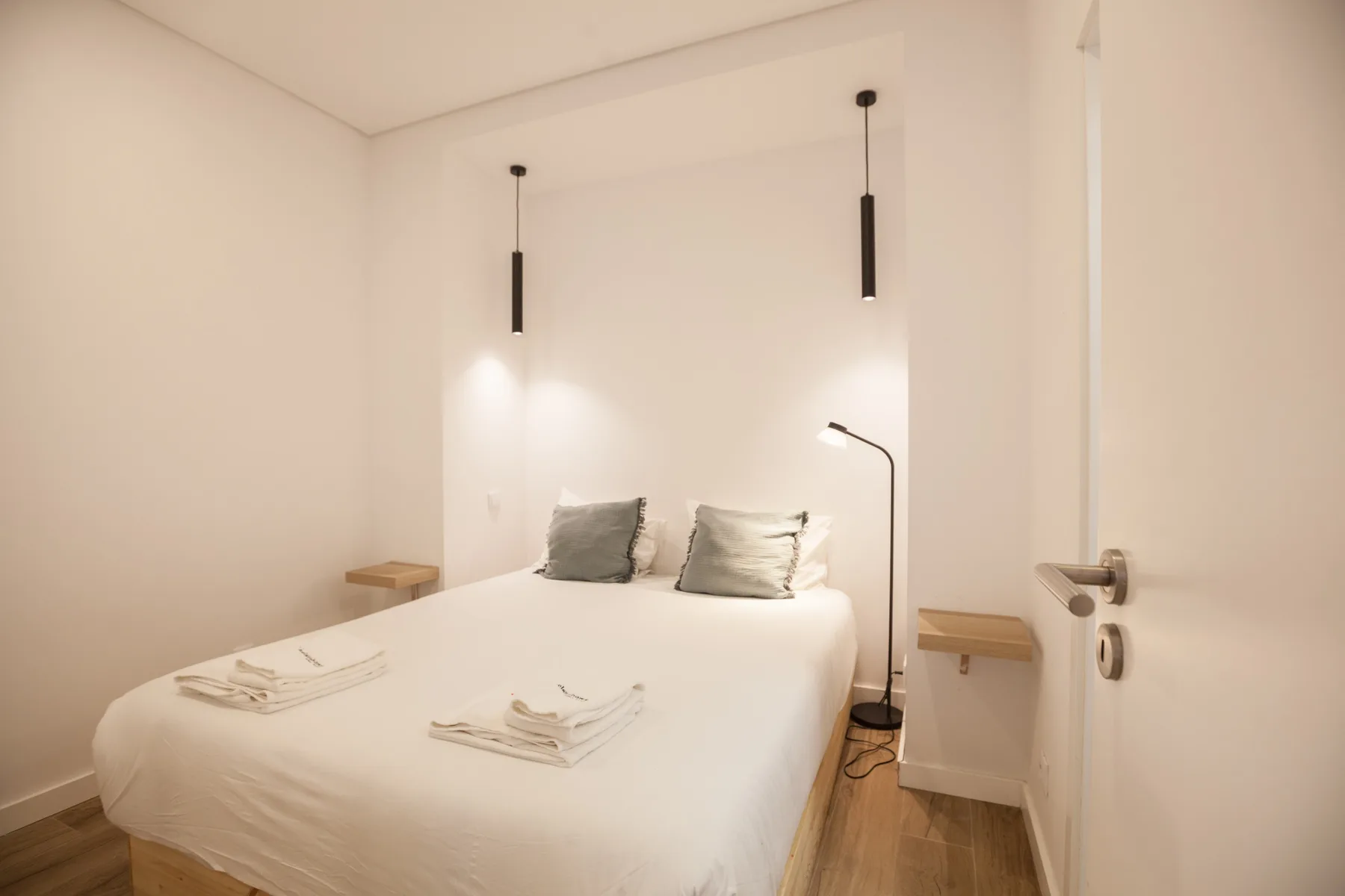 A bedroom with a neatly made bed and two bedside tables.