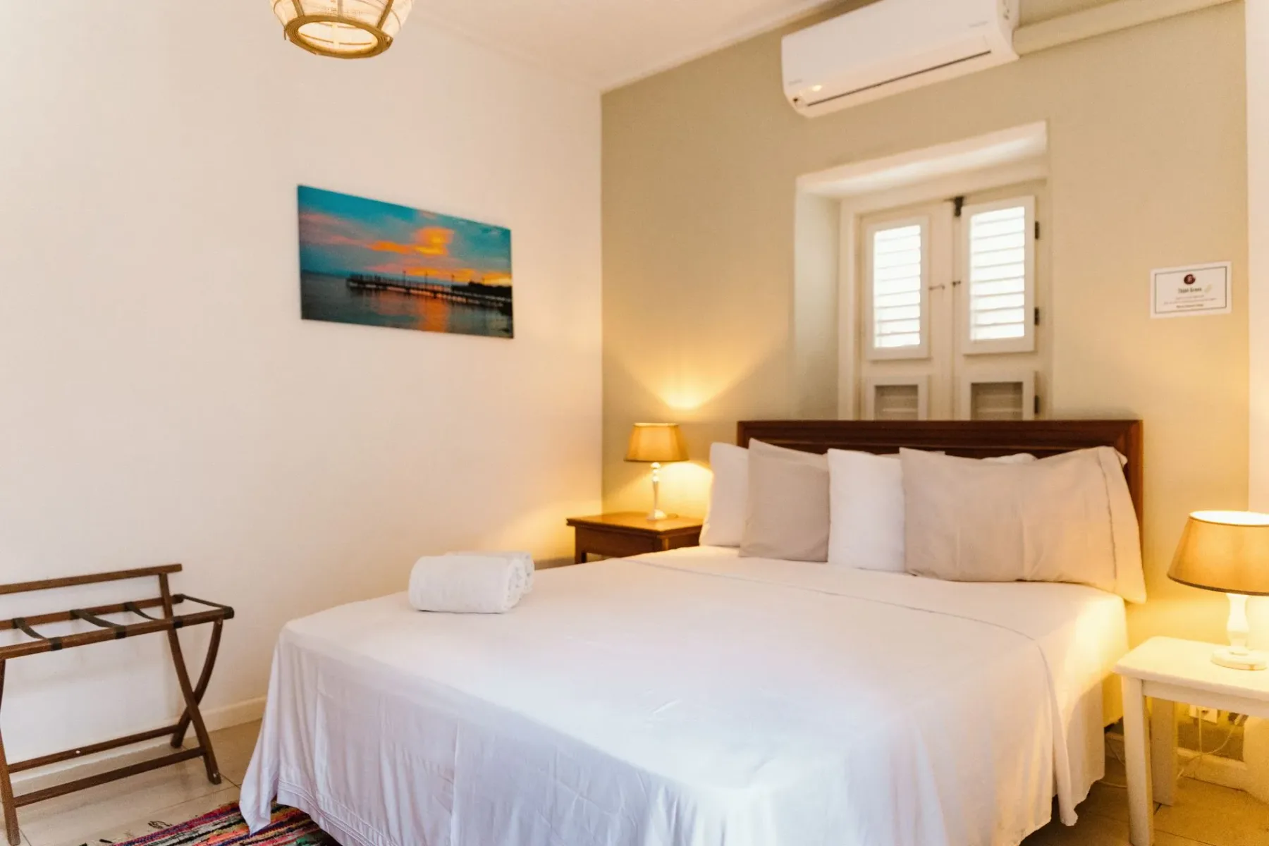 Dormitorio con una cama queen y aire acondicionado montado en la pared.