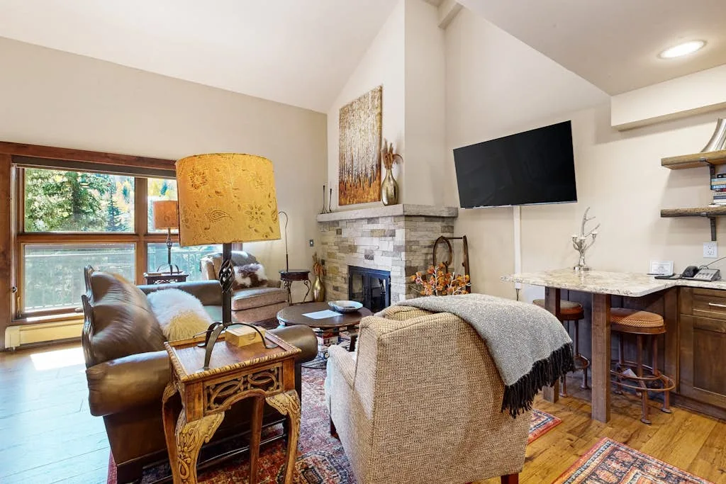 Una sala de estar con asientos alrededor de una chimenea y un televisor.