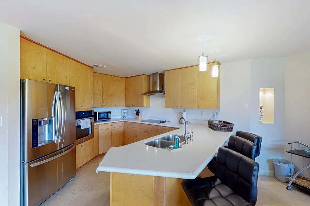 A bright kitchen with wooden cabinets and a large central island.