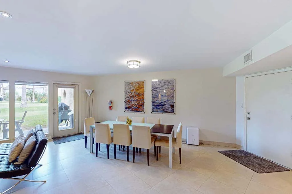 A dining area with a table and chairs beside large glass doors.