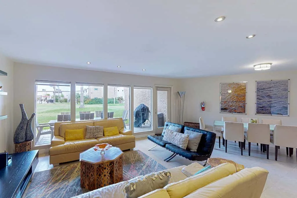 A bright living and dining area with seating arranged around a coffee table.