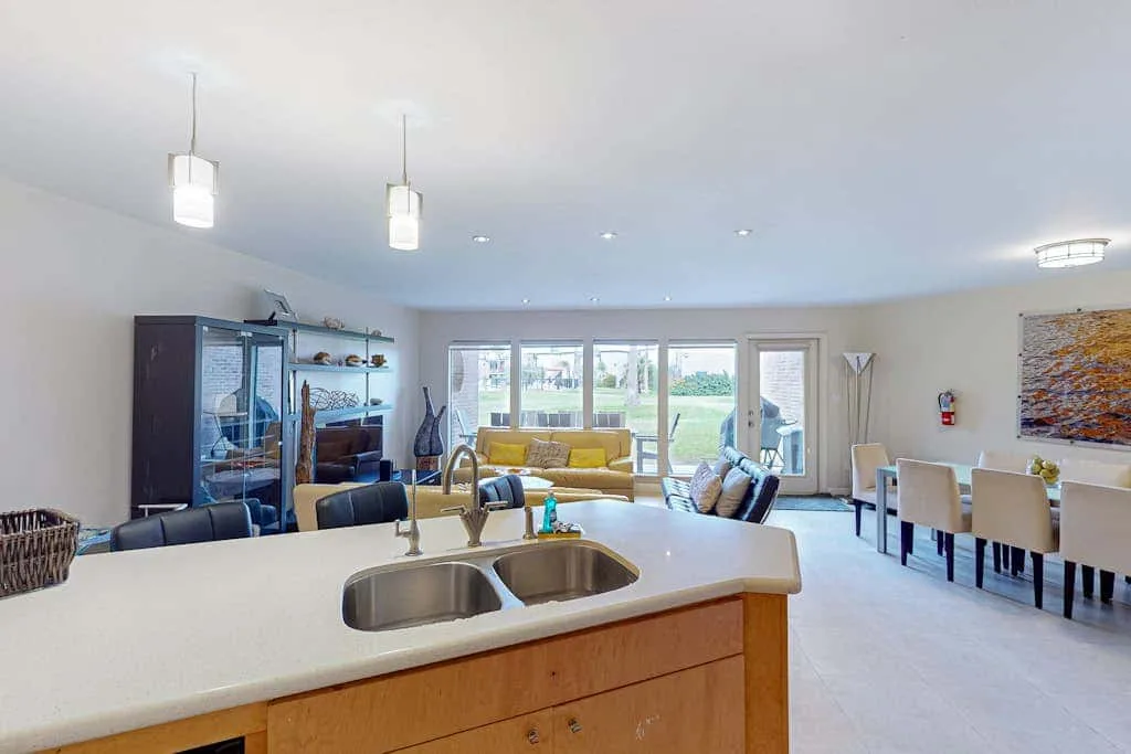 An open-plan kitchen and dining area with a countertop facing large windows.